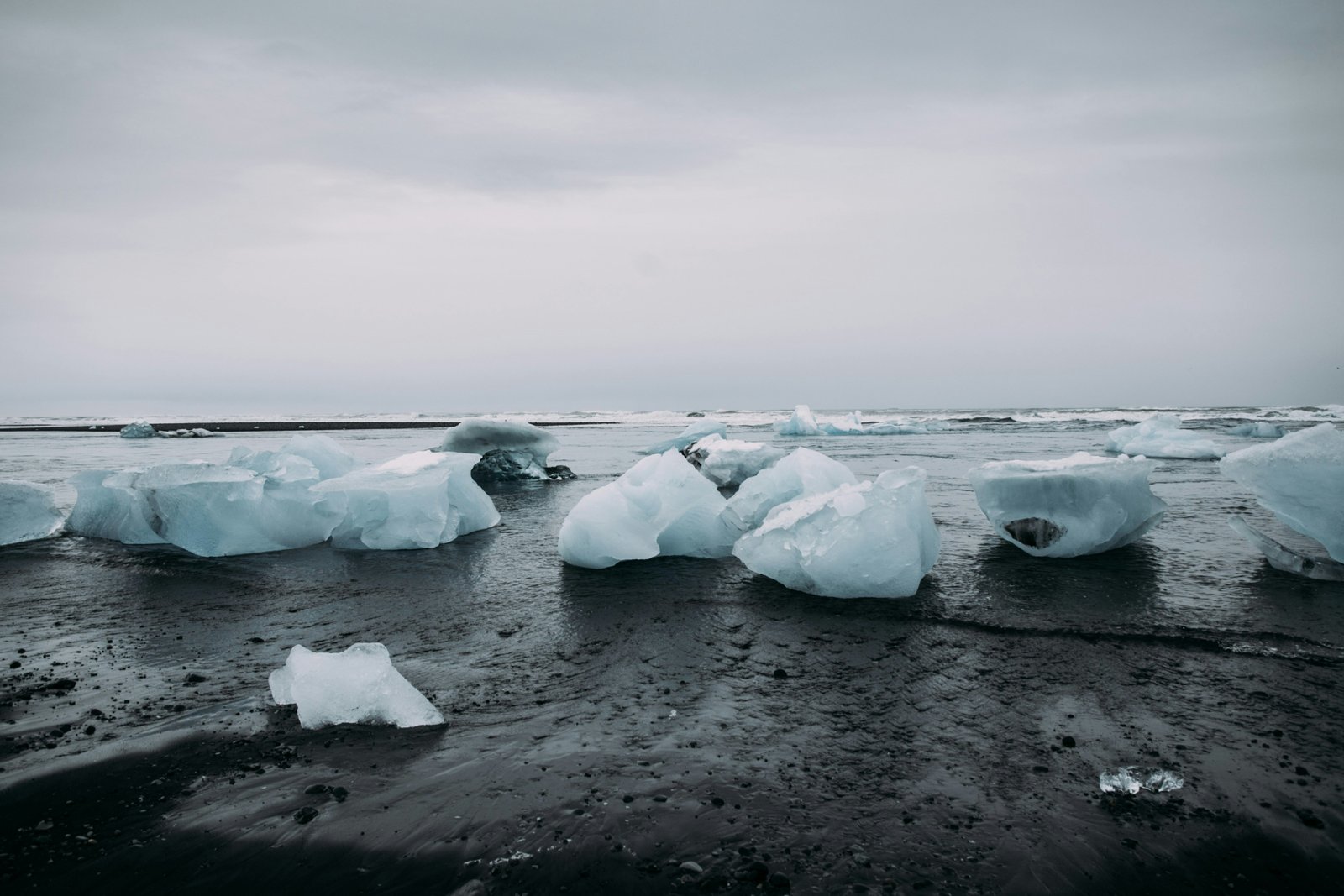 Broken pieces of glaciers on a black sand beach