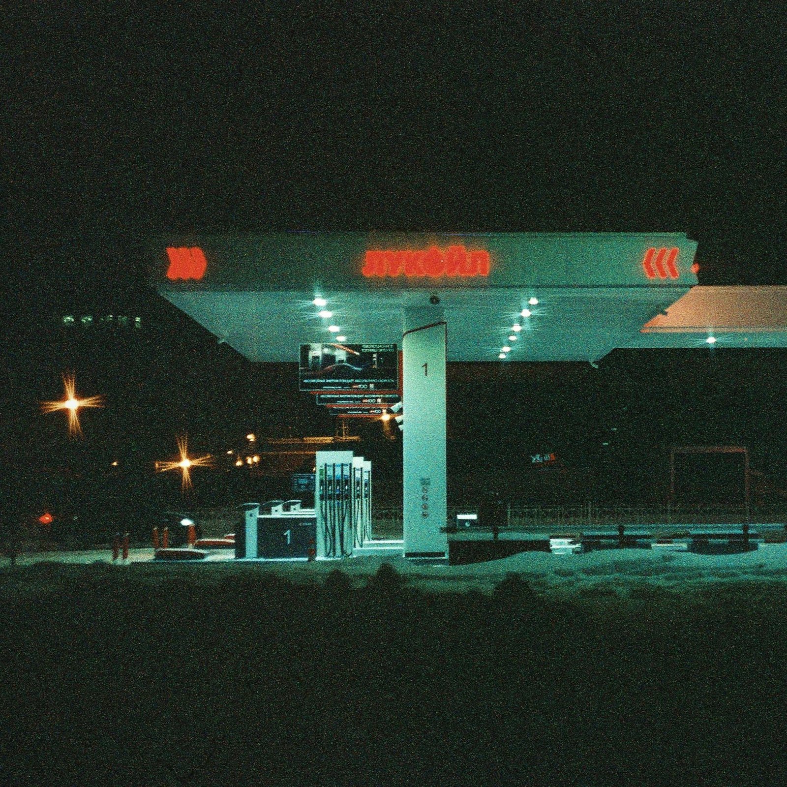 A dark gas station bathed in neon light